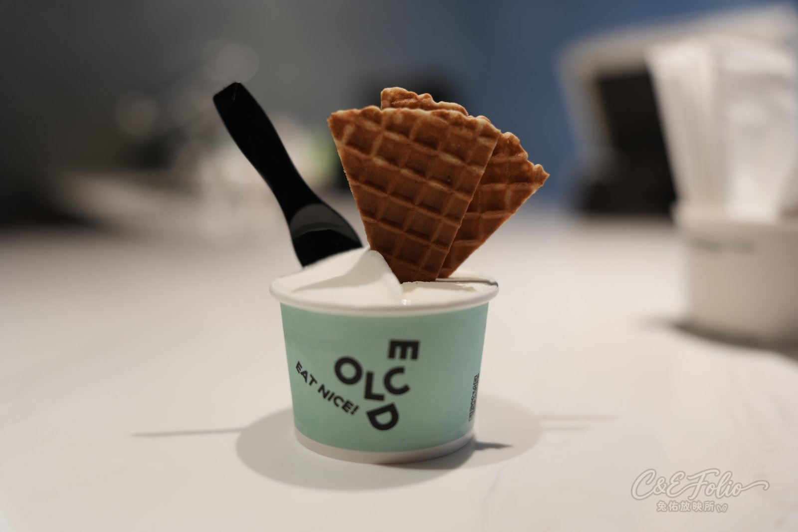 綠色紙杯裝的義式冰淇淋,插著鬆餅片和黑色小湯匙