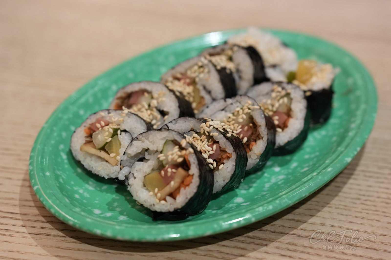 綠色盤子上切好的飯捲
